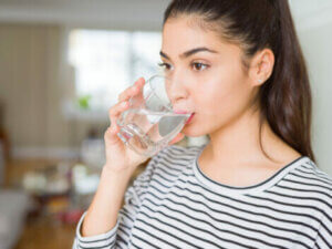 A woman drinking a glass of water.