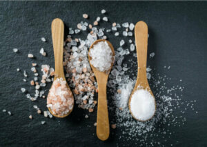 Three wooden spoons containing mineral salts, which are one of the causes of fluid retention.