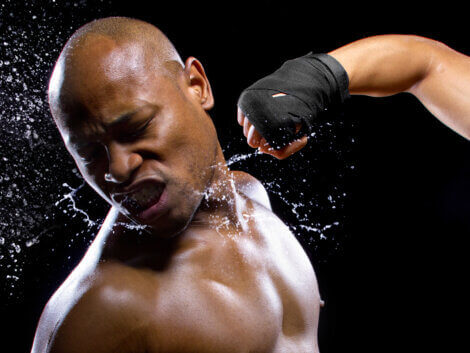 A boxer getting hit in the face.