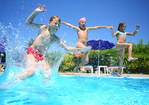 Children jumping into a swimming pool.