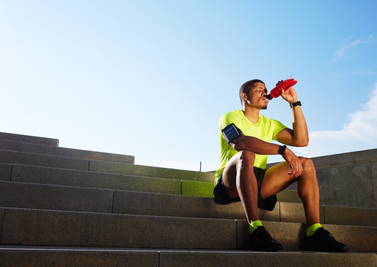 A man drinking a sports drink.