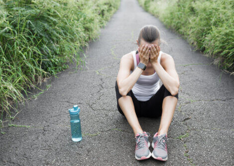 A frustrated woman sitting on a path.