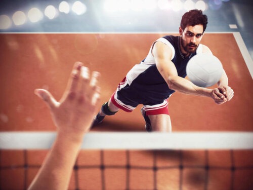 A man serving during a volleyball match.