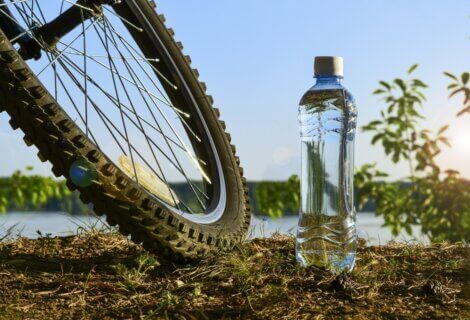 A bottle of water sitting next to a bicycle.