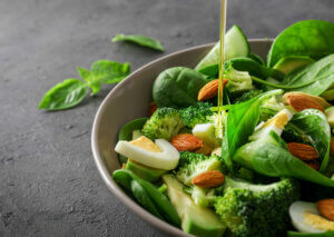 A bowl of green leafy vegetables which contain vitamin K.