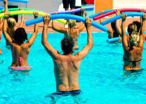 A group of people performing water aerobics.