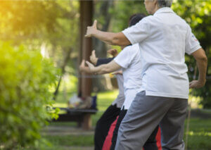 A group performing Chi Kung practice outside.