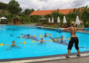 A woman leading a water aerobics session.