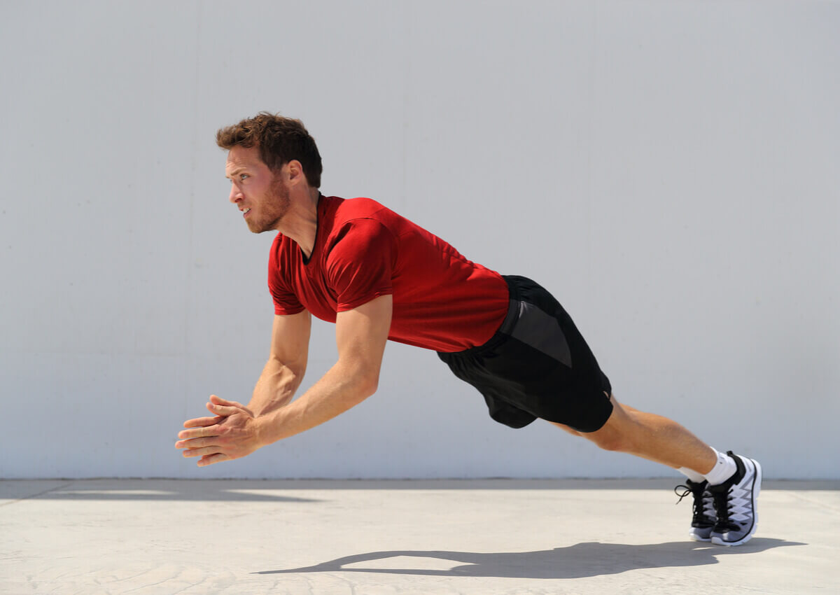A man doing a clapping push-up.