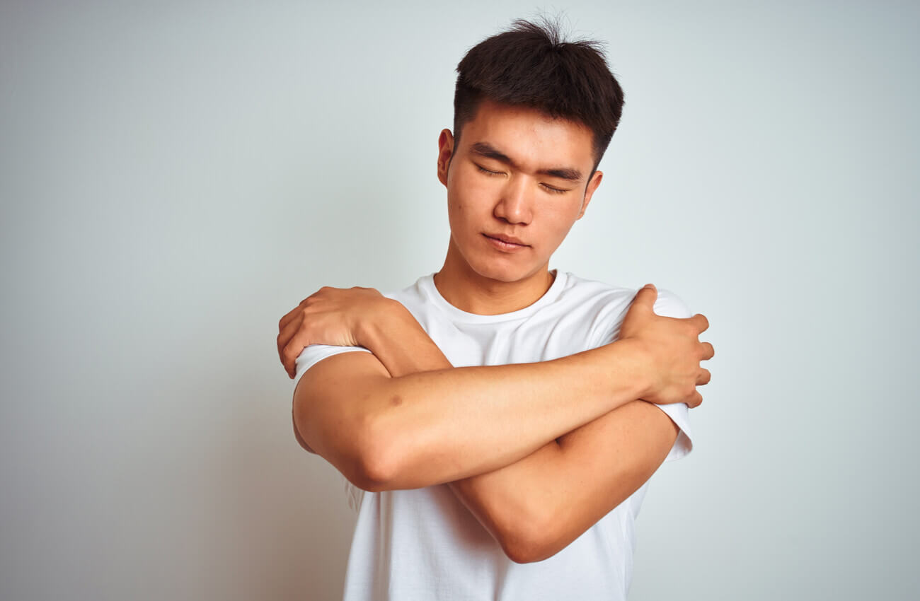 A man hugging himself.