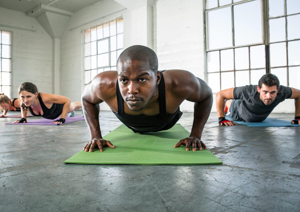 Three people doing push-ups.