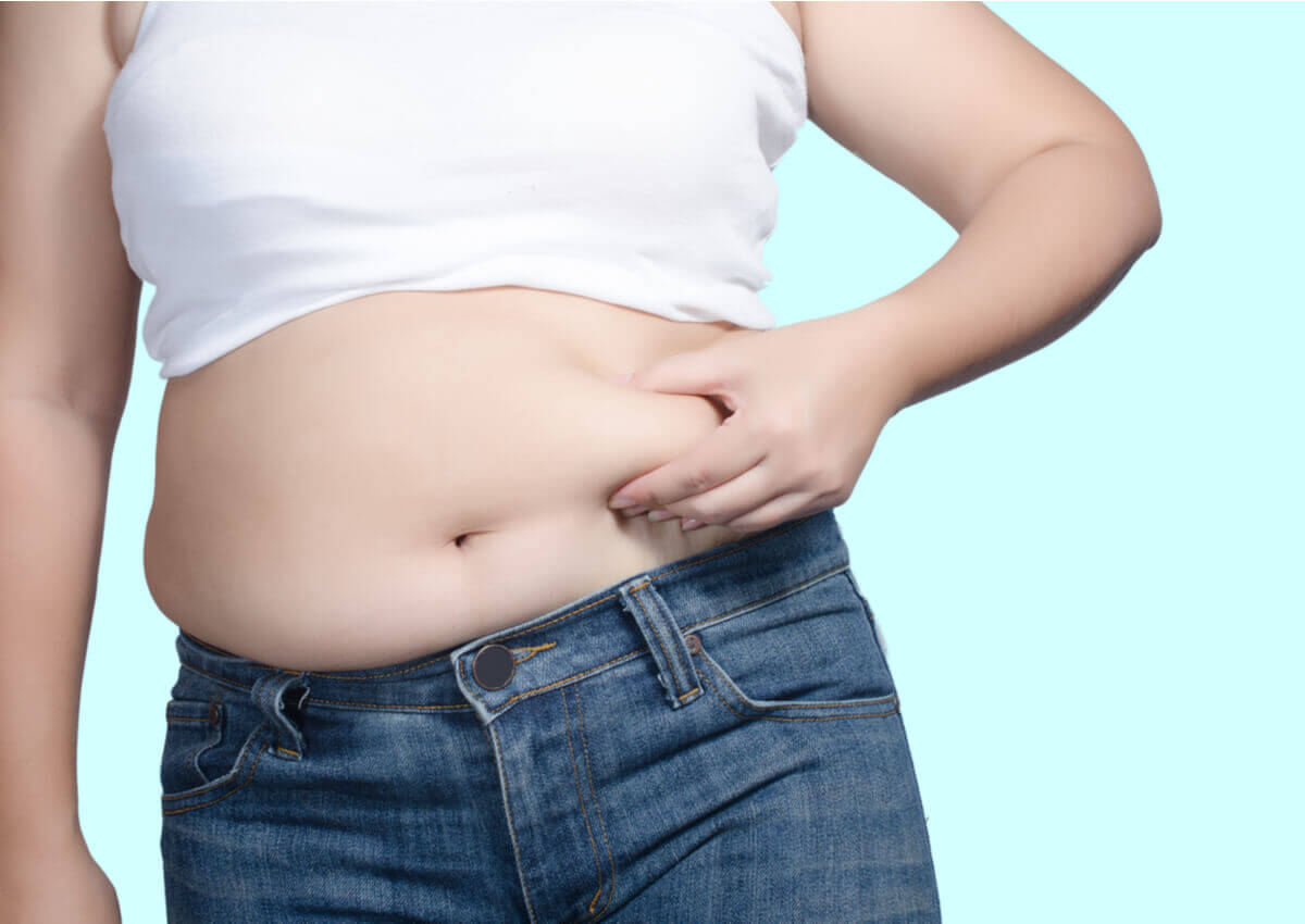 A person holding their belly fat.