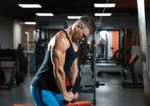 A man performing a tricep push-down in the gym.