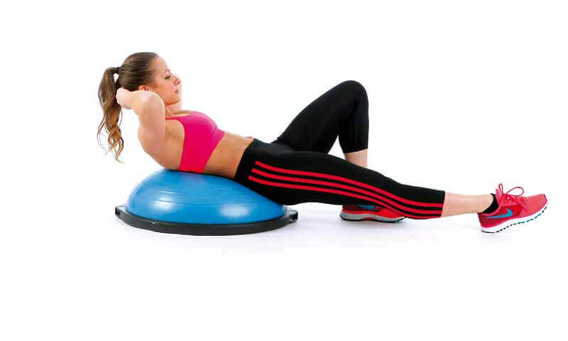 A woman doing situps on a BOSU.