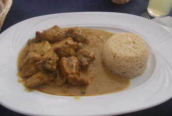 A plate of chicken curry and rice.