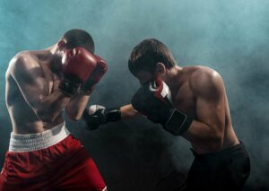 Two people boxing correctly to prevent injuries in this contact sport.
