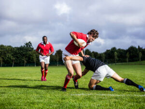 Two players in a rugby tackle.
