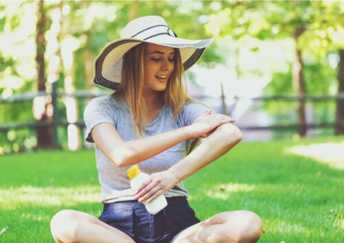 A woman putting on sunscreen.