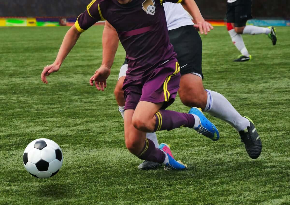A soccer player suffering an ankle injury during a game.