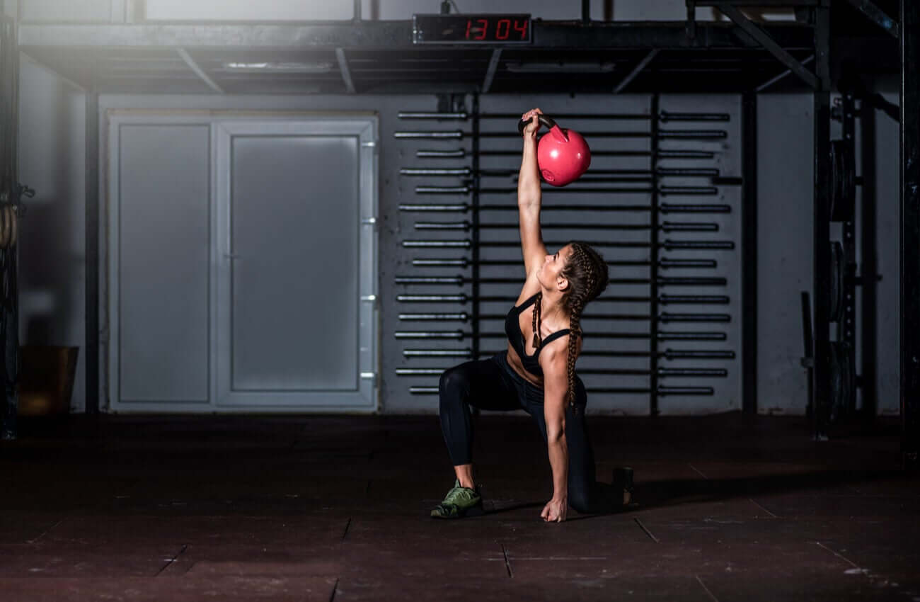 A woman doing a kettlebell grinder.