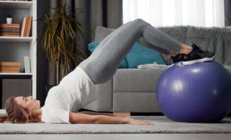 A woman doing a glute bridge with a fit ball.