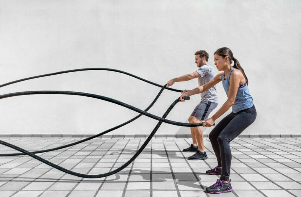 two people using ropes in the gym