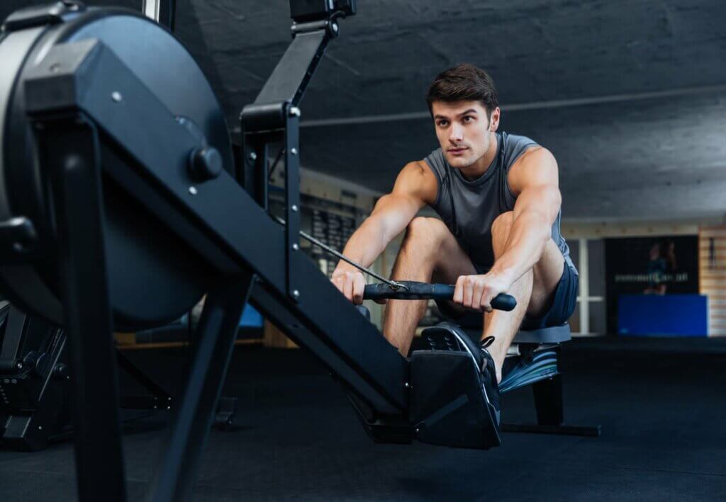 young man training on a machine at the gym