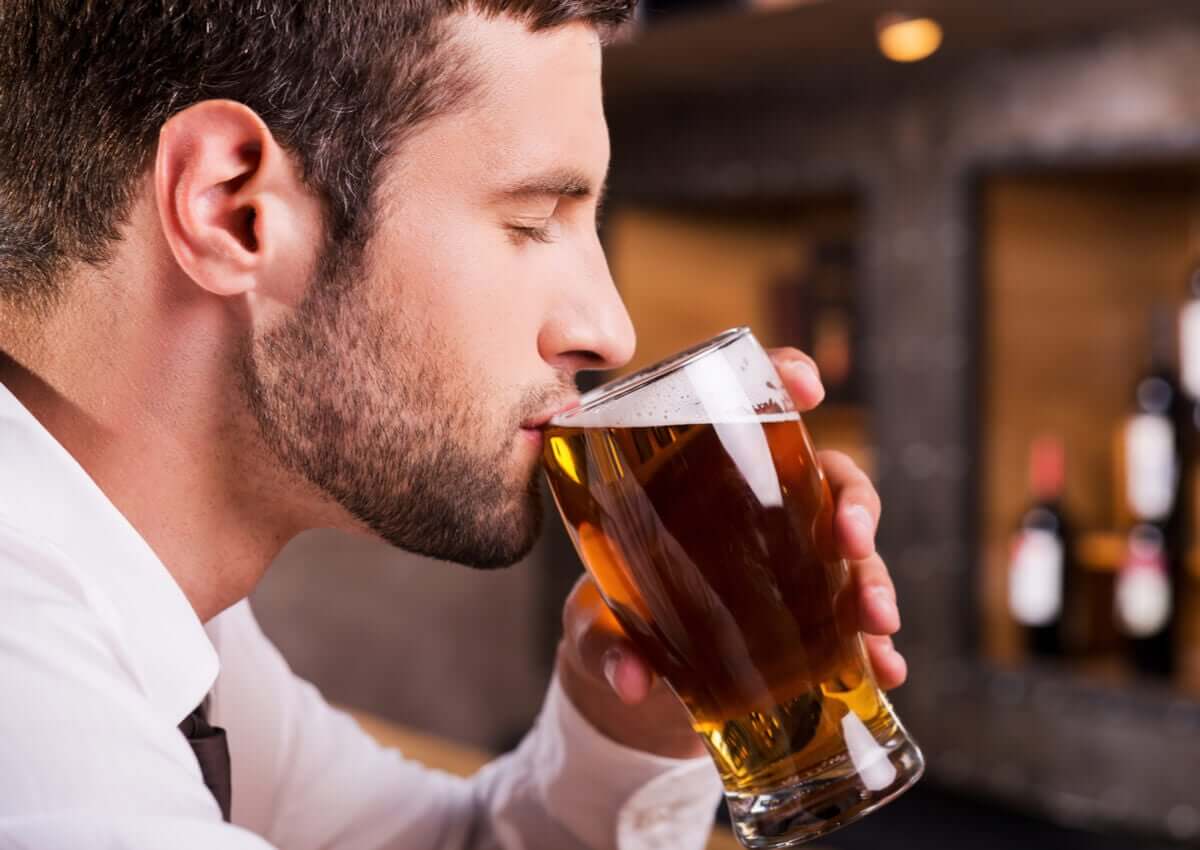 Um homem bebendo uma cerveja.